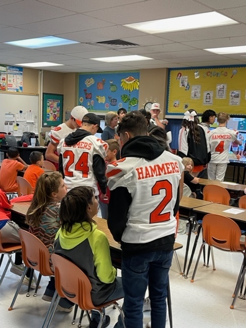 Football boys interacting with elementary students